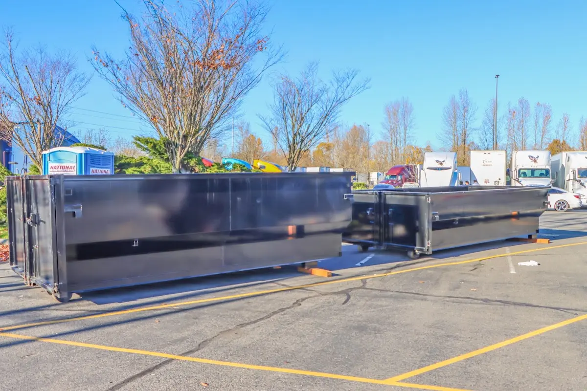 Professional dumpster rental service with roll-off container on residential driveway in East Haddam